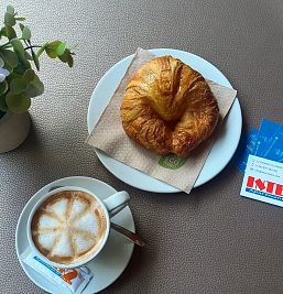 Café recién preparado acompañado de un croissant en Inter2, ideal para un desayuno delicioso.