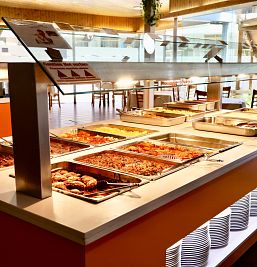 Buffet en Inter2 con desayuno inglés completo, variedad de postres, platos fríos y calientes, incluyendo hamburguesas y pollo.