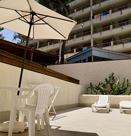 Terraza privada en planta baja del Inter2 Salou, con mobiliario exterior y vistas al jardín.