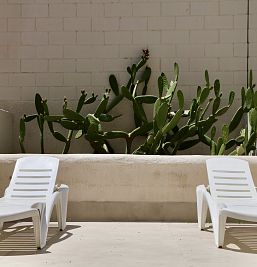 Terraza privada en planta baja del Inter2 Salou, con mobiliario exterior y vistas al jardín.