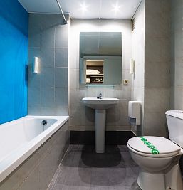 Baño moderno y funcional en el estudio Inter2 Salou, con ducha, lavabo y toallas incluidas.