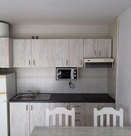 Vvista frontal de la cocina en InterApartments, con muebles funcionales y equipamiento completo para estancias turísticas.