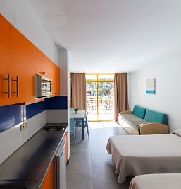Vista del interior del estudio en Inter2 Salou, con espacios bien distribuidos, zona de estar con sofá, cocina equipada y estilo contemporáneo.