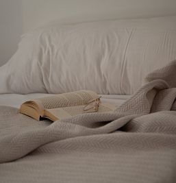 Libro y gafas sobre la cama en una habitación confortable de Inter2 Salou, ideal para momentos de descanso.
