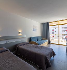 Vista del interior del estudio en Inter2 Salou, con espacios bien distribuidos, zona de estar con sofá, cocina equipada y estilo contemporáneo.