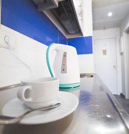 Cocina del apartamento Inter2 con encimera equipada, destacando una tetera sobre la superficie.  Inglés:
