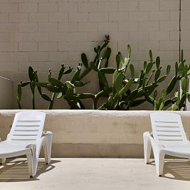 Terraza privada en planta baja del Inter2 Salou, con mobiliario exterior y vistas al jardín.